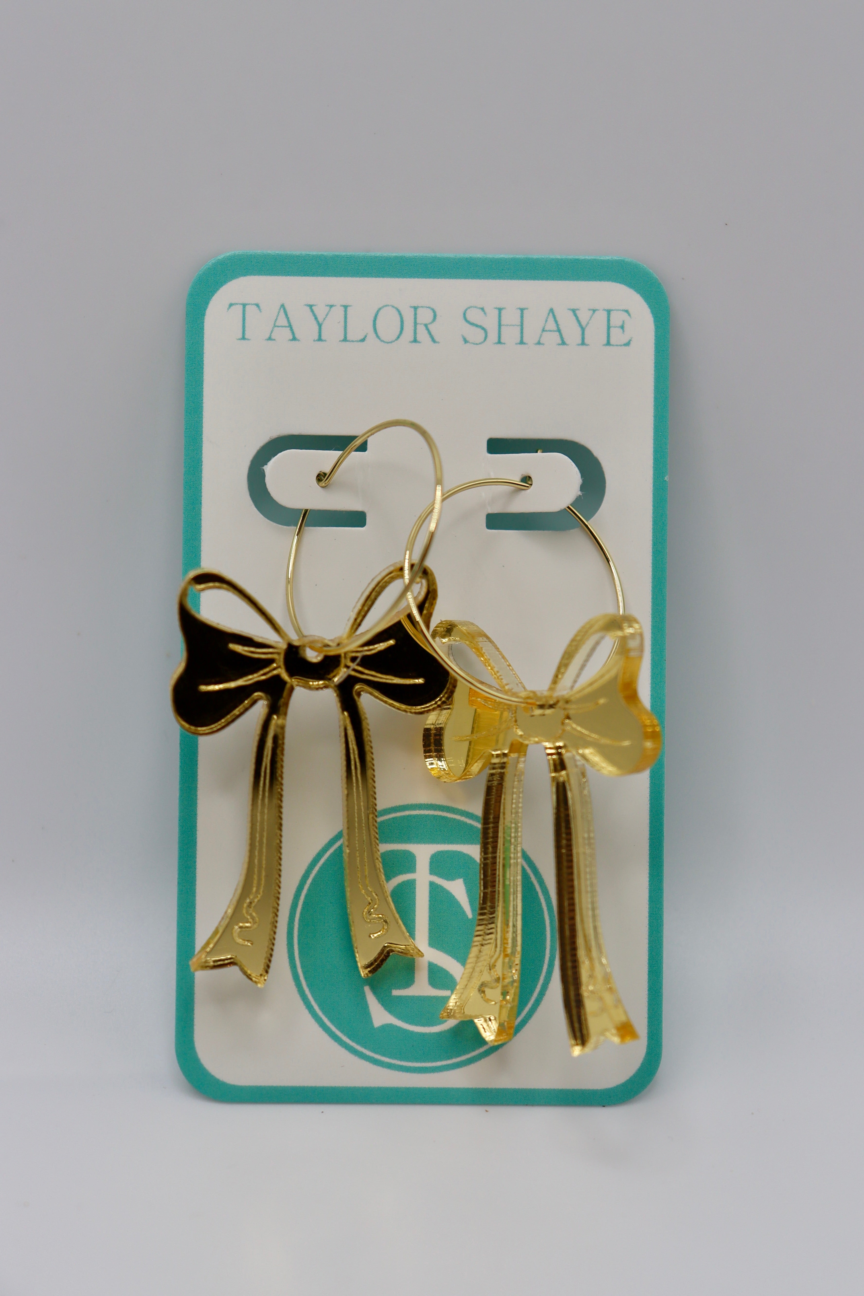 Taylor Shaye Game Day Bow Hoops!

Gold acrylic bows on a gold hoop.
2 1/4" drop.
Made by Taylor Shaye.