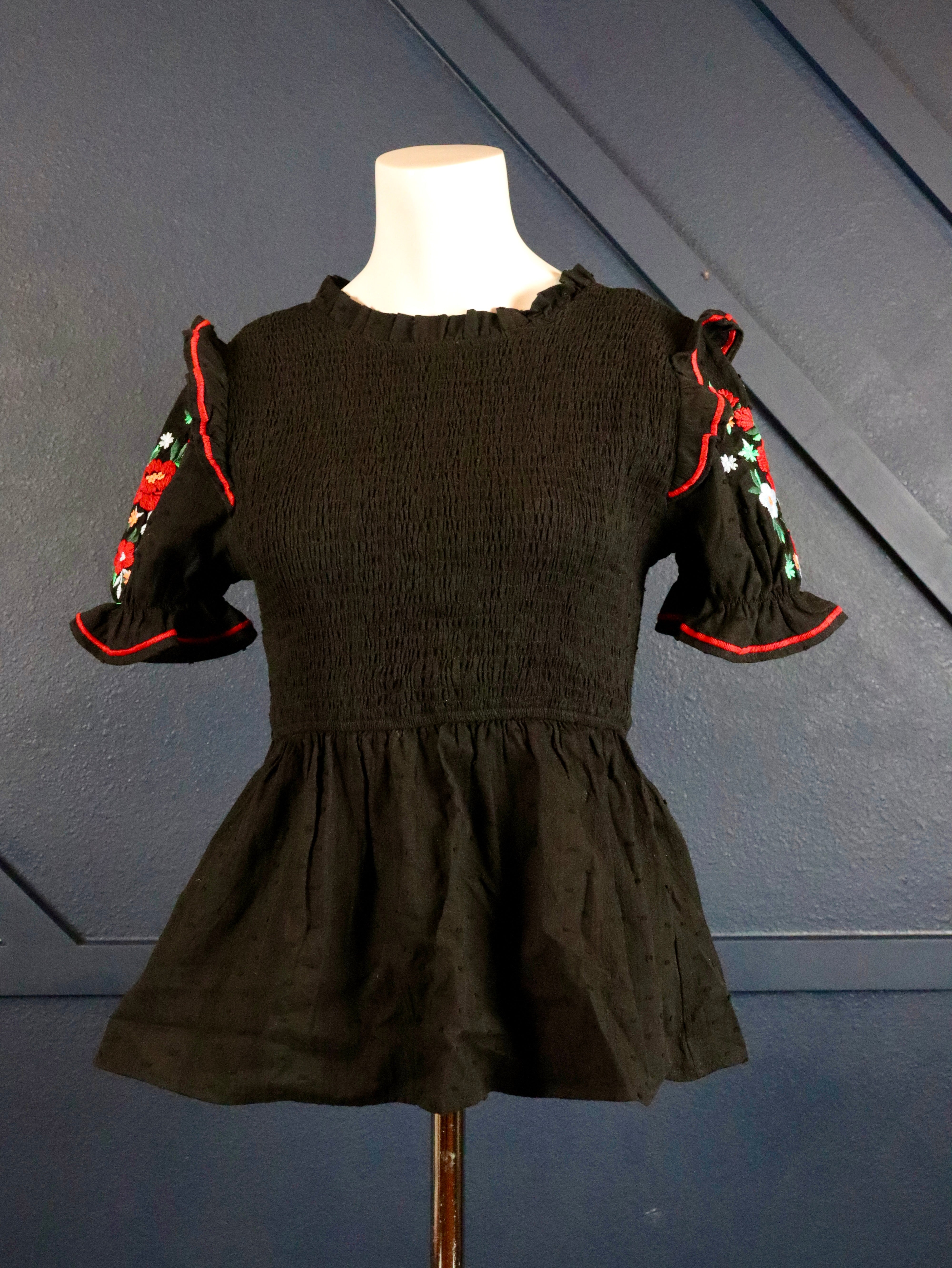 This black smocked embroidered top pairs well with white denim. 
Floral embroidered short puffy sleeves with a smocked bodice.
100% Cotton
Made by Savanna Jane
Small (0-2)
Medium (4-6)
Large (8-10)