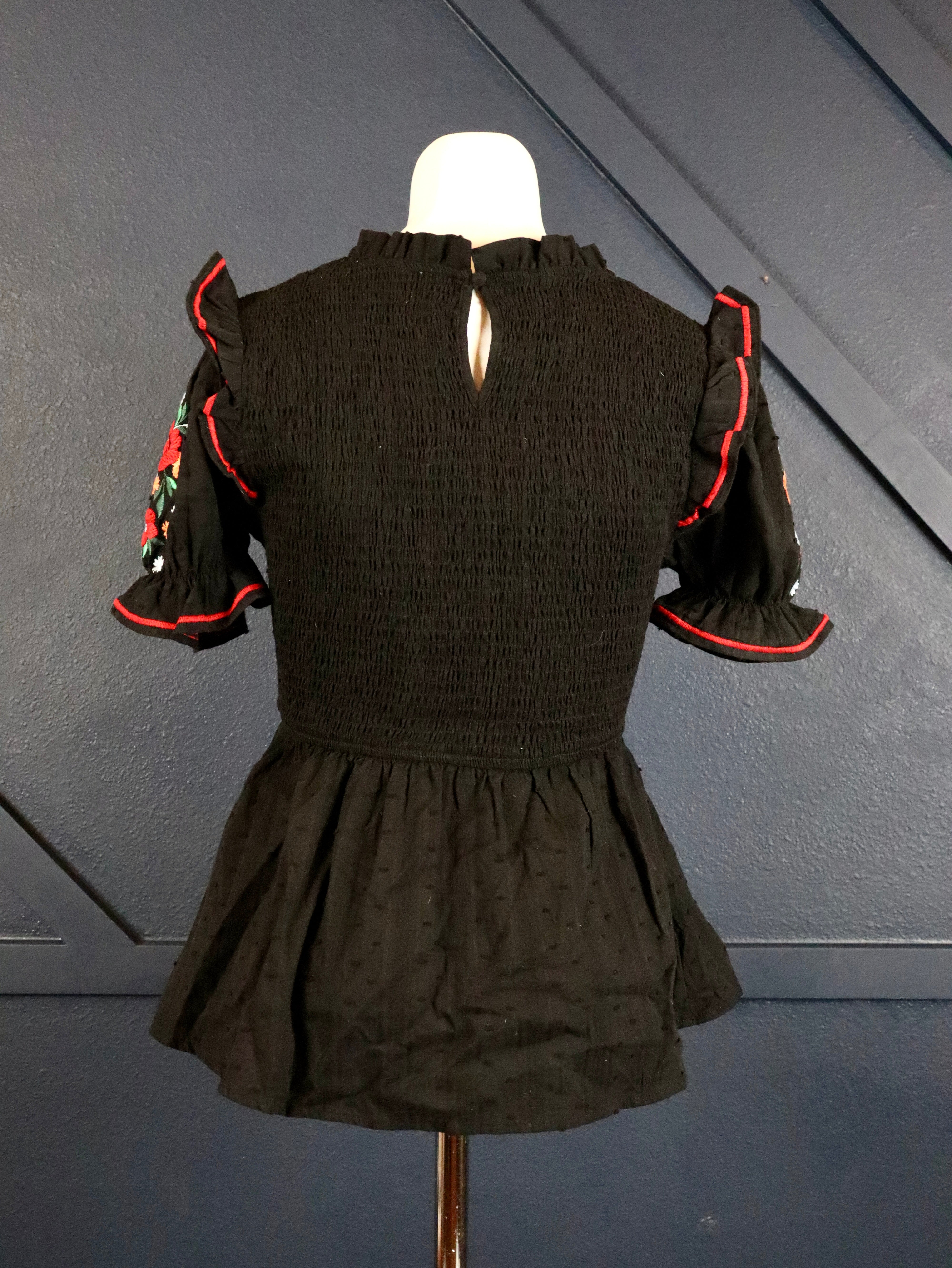 This black smocked embroidered top pairs well with white denim. 
Floral embroidered short puffy sleeves with a smocked bodice.
100% Cotton
Made by Savanna Jane
Small (0-2)
Medium (4-6)
Large (8-10)