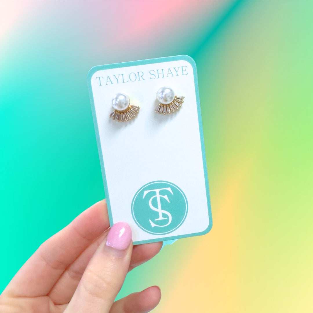 Pearl and rhinestone studs.

Classic and will compliment any style.
Made by Taylor Shaye in the USA.
Kendra Scott