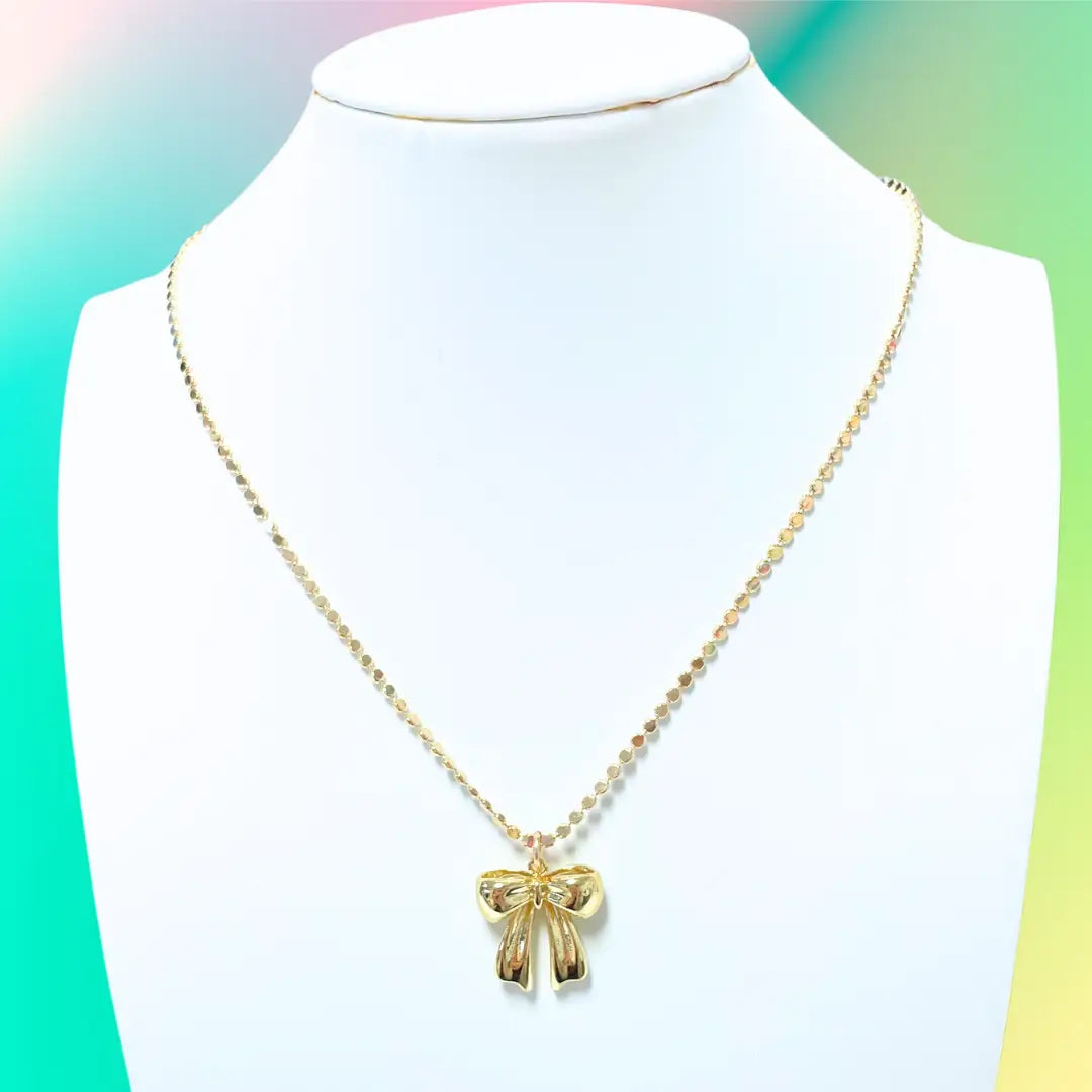 Gold bow necklace.

Gold bow necklace made by Taylor Shaye.