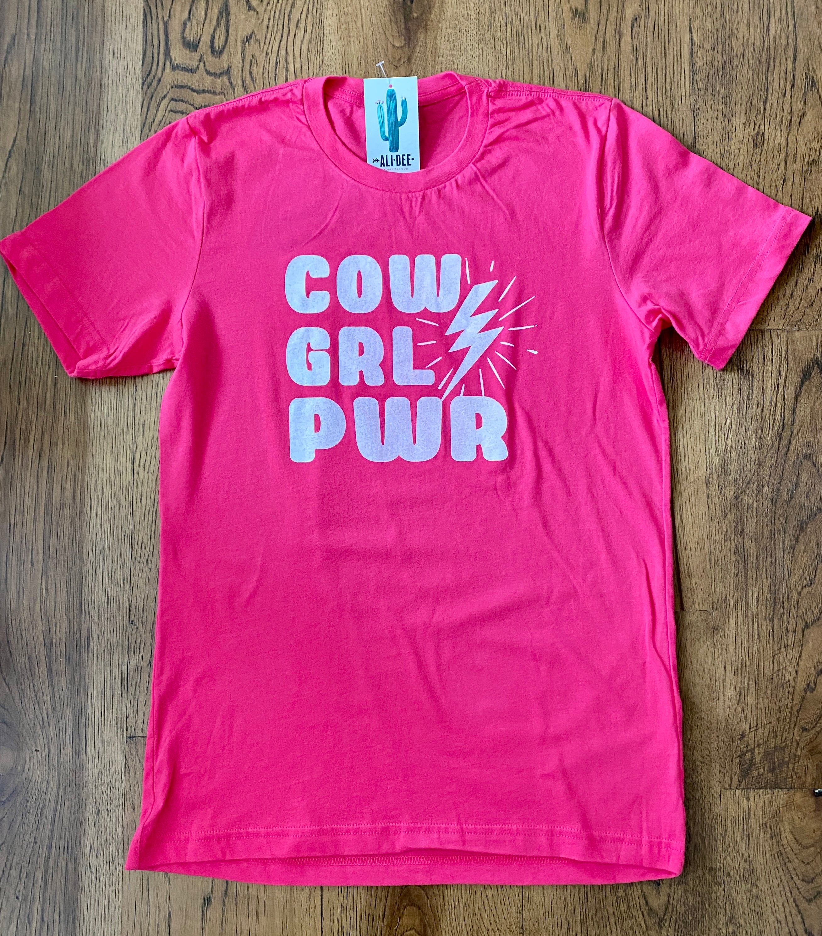 COW GRL PWR Tee features a unisex fit body in pink with cream screen printed art. 